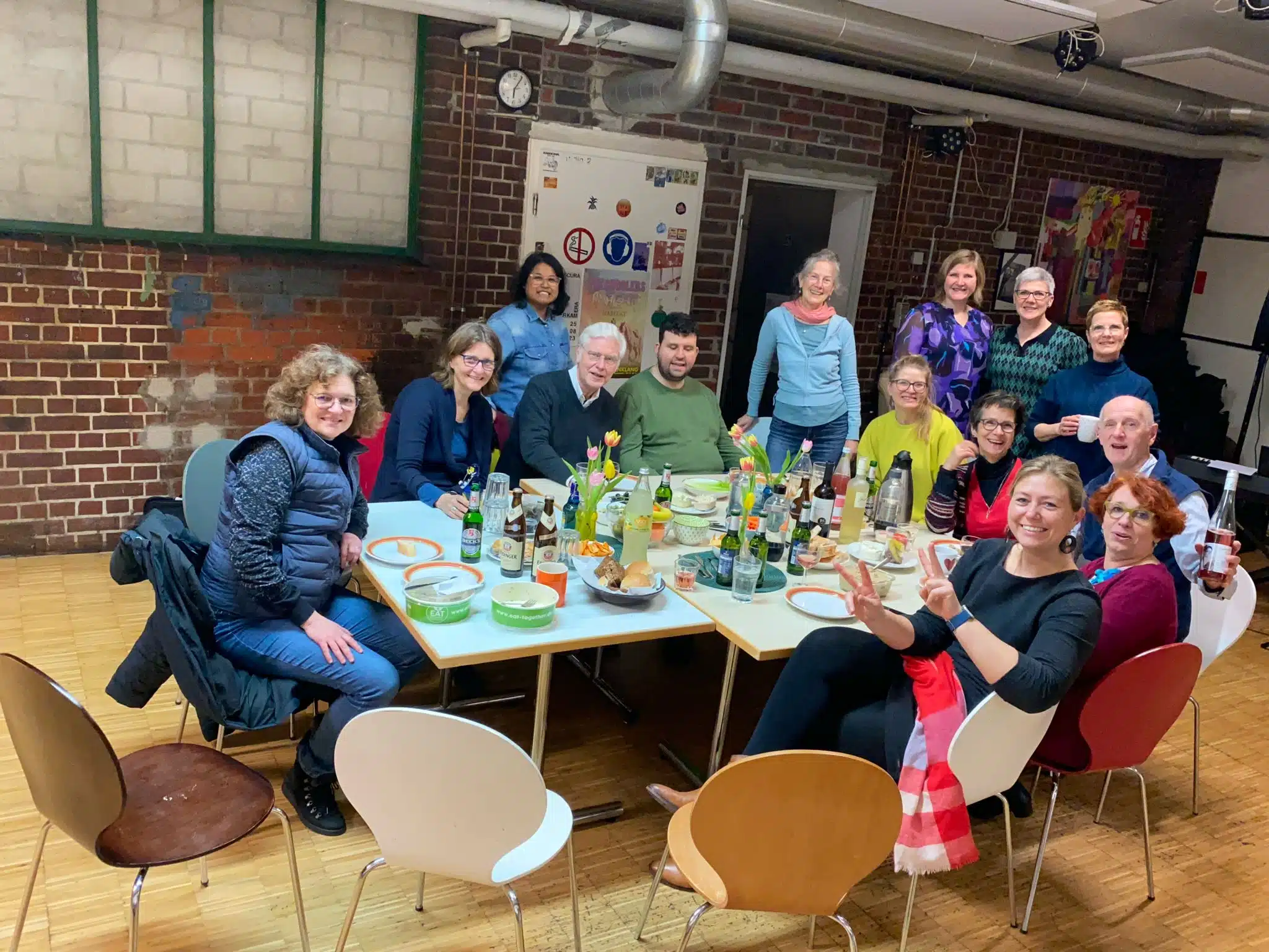 TeilnehmerInnen und Coaches beim gemeinsamen Essen an einer langen Tafel